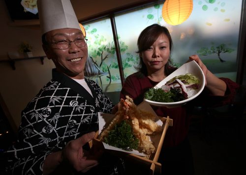 Gami Sushi owners Sushi Chef Doeyeong Kang (left) and his wife Hyunhee Park pose holding Shrimp Tempura and Sunomono Salad respectively. See Marion's review. December 16, 2013 - (Phil Hossack / Winnipeg Free Press)