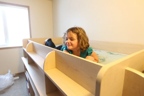 Seven year old Cadence tries out her bed after it was taken out of storage and set up for her in her new bedroom .   Photo Essay on the Van De Kaere family (including  Cadence, Shannon, Rene and Brendon) finally moving into their Habitat home just  in time for Christmas.  Dec 16, 2013 Ruth Bonneville / Winnipeg Free Press
