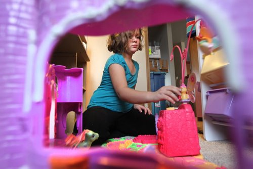 Seven year old Cadence  plays with toys that had been in storage for a year and a half on the floor of her new bedroom. Photo Essay on the Van De Kaere family (including  Cadence, Shannon, Rene and Brendon) finally moving into their Habitat home just  in time for Christmas.  Dec 16, 2013 Ruth Bonneville / Winnipeg Free Press