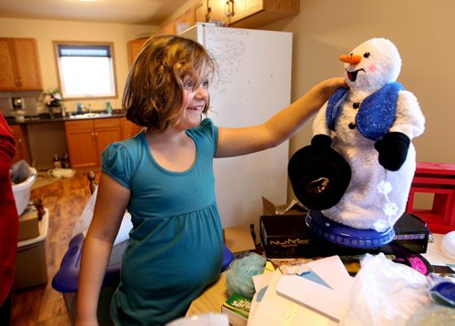 Cadence smiles as she watches her dancing snowman as the family sets up their home for Christmas.  Photo Essay on the Van De Kaere family (including  Cadence, Shannon, Rene and Brendon) finally moving into thier Habitat home just  in time for Christmas.  Dec 16, 2013 Ruth Bonneville / Winnipeg Free Press