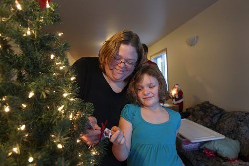 Shannon and her daughter Cadence share a warm embrace in front of their Christmas tree while setting up for Christmas i their new home.  Photo Essay on the Van De Kaere family (including  Cadence, Shannon, Rene and Brendon) finally moving into thier Habitat home just  in time for Christmas.  Dec 16, 2013 Ruth Bonneville / Winnipeg Free Press
