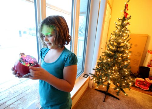 Cadence looks at a instrumental Christmas  decoration while helping to set up for Christmas.  Photo Essay on the Van De Kaere family (including  Cadence, Shannon, Rene and Brendon) finally moving into thier Habitat home just  in time for Christmas.  Dec 16, 2013 Ruth Bonneville / Winnipeg Free Press