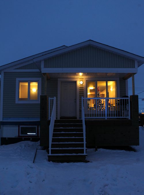 As dusk settles  outside a warm glow beams from the windows of the Van De Kaere families new home just a couple days after taking possession of it.  Photo Essay on the Van De Kaere family (including  Cadence, Shannon, Rene and Brendon) finally moving into their Habitat home just  in time for Christmas.  Dec 16, 2013 Ruth Bonneville / Winnipeg Free Press