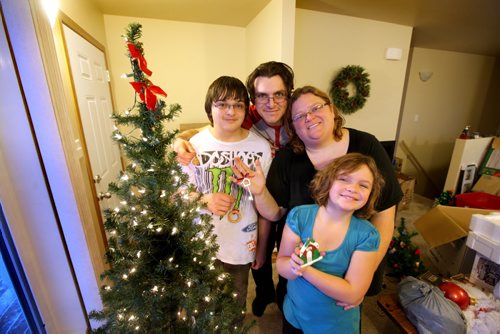 Family pose in front of their dressed Christmas tree in their new habitat home in Elmwood.  Photo Essay on the Van De Kaere family (including  Cadence, Shannon, Rene and Brendon) finally moving into their Habitat home just  in time for Christmas.  Dec 16, 2013 Ruth Bonneville / Winnipeg Free Press