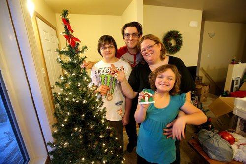 Family pose in front of their dressed Christmas tree in their new habitat home in Elmwood.  Photo Essay on the Van De Kaere family (including  Cadence, Shannon, Rene and Brendon) finally moving into their Habitat home just  in time for Christmas.  Dec 16, 2013 Ruth Bonneville / Winnipeg Free Press