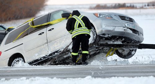 A tow truck operator secures a vehicle that was in the ditch,  it was involved in a single motor vehicle collision on  he south Perimter Highway near  Plesis Road earlier Tuesday morning. Wayne Glowacki / Winnipeg Free Press Dec.17. 2013