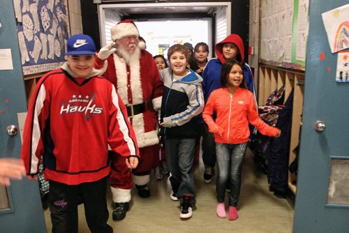 Santa greets kids at the Wanipigow school on the Hallow Water First Nation after arriving with MKO Grand Chief David Harper during the Santa Express tour.  131218 December 18, 2013 Mike Deal / Winnipeg Free Press