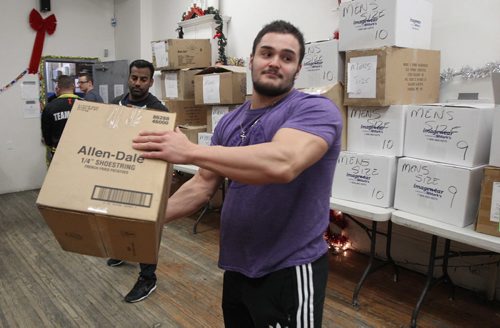 Anthony Guzzi From Gorilla Jack Supplements volunteered his brawn along with number of other volunteers that delivered 250 emergency hampers and 300 new pairs of winter boots to Lighthouse Mission Wednesday. The volunteers, many of them local athletes, are making a difference in meeting basic needs of some of Winnipeg's less fortunate people.- See Ashley Prest story- Dec 18, 2013   (JOE BRYKSA / WINNIPEG FREE PRESS)