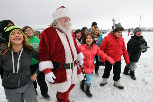 Santa is greeted by kids as he arrives by helicopter at the Black River Anishinabe School on the Little Black River First Nation with MKO Grand Chief David Harper during the Santa Express tour.  131218 December 18, 2013 Mike Deal / Winnipeg Free Press
