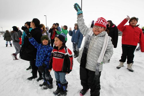 Children wave as Santa arrives by helicopter at the Black River Anishinabe School on the Little Black River First Nation with MKO Grand Chief David Harper during the Santa Express tour.  131218 December 18, 2013 Mike Deal / Winnipeg Free Press