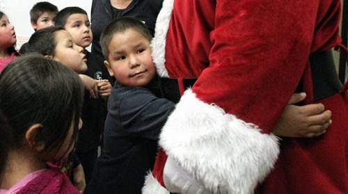 Alfred Harry, 6, gives Santa a big hug after he arrived by by helicopter at the Black River Anishinabe School on the Little Black River First Nation with MKO Grand Chief David Harper during the Santa Express tour.  131218 December 18, 2013 Mike Deal / Winnipeg Free Press