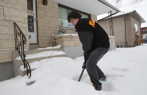 Snow Angels volunteer Riley LeBlanc works on clearing a sidewalk on Speers Road Wednesday- see Rachel Swatek story- Dec 18, 2013   (JOE BRYKSA / WINNIPEG FREE PRESS)