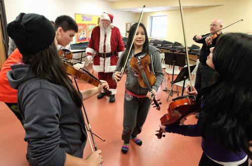 A fiddling class gives an impromptu performance for Santa during his visit to the Black River Anishinabe School on the Little Black River First Nation with MKO Grand Chief David Harper during the Santa Express tour.  131218 December 18, 2013 Mike Deal / Winnipeg Free Press