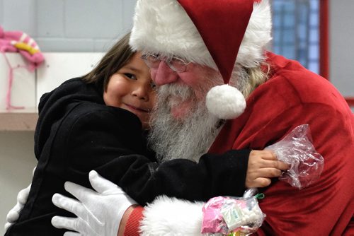 Kayden Swampy, 4, gives Santa a big hug as he visits the Sagkeeng First Nation during his Santa Express tour Wednesday. 131218 - December 18, 2013 MIKE DEAL / WINNIPEG FREE PRESS