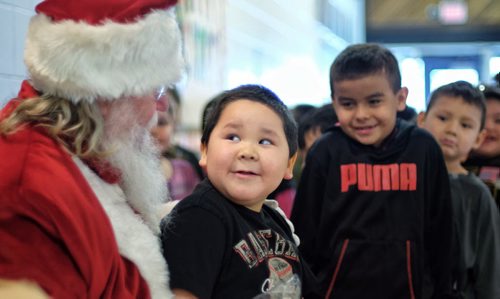 Jacoby Smith, 5, gives Santa a look as he talks to him during Santa's visit to Wanipigow School on the Hallow Water First Nation during his Santa Express tour Wednesday. 131218 - December 18, 2013 MIKE DEAL / WINNIPEG FREE PRESS