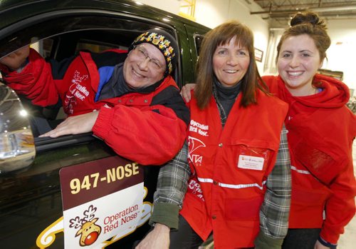 Allan Kauk, Michele Rousseau and her daughter Janelle Asselin are volunteers at Operation Red Nose. BORIS MINKEVICH / WINNIPEG FREE PRESS  December 19, 2013