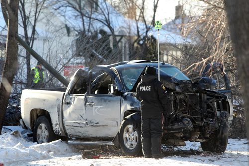 Winnipeg Police Officers survey the scene of a single vehicle accident on Crystal Ave. in St. Vital that  left one person in hospital Saturday.  See story. Dec 21, 2013 Ruth Bonneville / Winnipeg Free Press