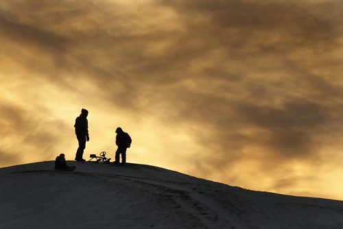 December 21, 2013 - 131221  -  A young family slides down "Garbage Hill" at Westview Park amid a setting sun Saturday, December 21, 2013. JOHN WOODS / WINNIPEG FREE PRESS. weather