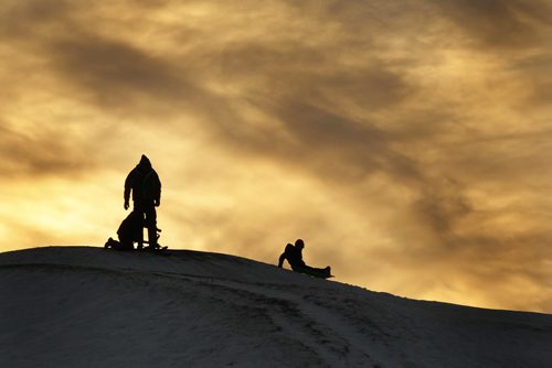 December 21, 2013 - 131221  -  A young family slides down "Garbage Hill" at Westview Park amid a setting sun Saturday, December 21, 2013. JOHN WOODS / WINNIPEG FREE PRESS. weather