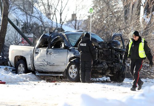 Winnipeg Police Officers survey the scene of a single vehicle accident on Crystal Ave. in St. Vital that  left one person in hospital Saturday.  See story. Dec 21, 2013 Ruth Bonneville / Winnipeg Free Press