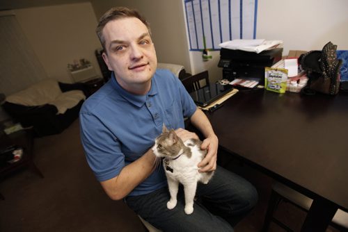 December 22, 2013 - 131222  -  Robb Hempel, a volunteer at CNIB, is photographed with his cat Phoebe in his apartment Sunday, December 22, 2013. For volunteer column. JOHN WOODS / WINNIPEG FREE PRESS