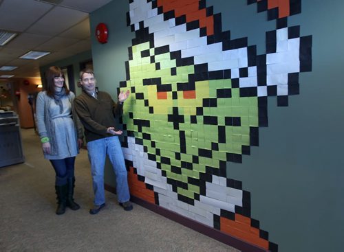 Dave Laroche and Tatjana Radulovic pose with Post-it notes masterpiece of the Grinch the IT department at Ducks Unlimited made for the Christmas season.-See Jessica Botelho-Urbanski story- Dec 23, 2013   (JOE BRYKSA / WINNIPEG FREE PRESS)