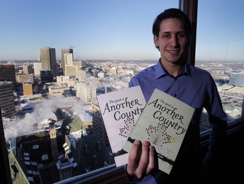 Gonzalo Agrimbau  with copies of the Past is Another Country with the Winnipeg Skyline from the lounge for the  Prairie 360 revolving restaurant hosting a Jan 8 fundraiser to publish Volume 3 of the book  it is made up of stories by newcomers who  took part in the Finding Your Voice program  a creative writing program that helps newcomers improve their English by telling their stories. Carol Sanders  story Wayne Glowacki / Winnipeg Free Press Dec.23. 2013