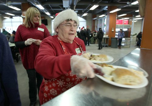 Volunteer Dianna Proctor serves the turkey at Christmas Eve dinner at the Siloam Mission this afternoon- 500 guests will be served by 110 volunteers eating 95 turkeys, 450 lbs of potatoes, and 85 pies- Standup photo- Dec 24, 2013   (JOE BRYKSA / WINNIPEG FREE PRESS)