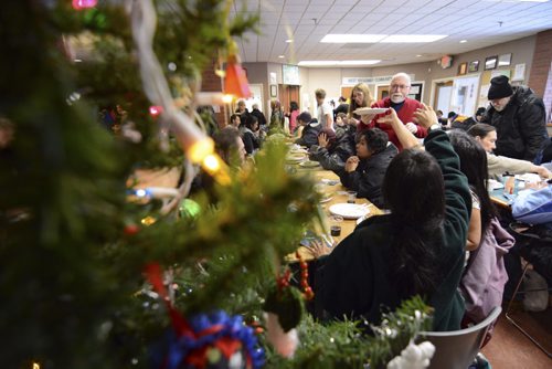 David Lipnowski / Winnipeg Free Press  Volunteer Larry Flynn serves up some Christmas cheer in the form of lunch at West Broadway Community Ministry during the annual Christmas lunch. The Shaarey Zedek Synagogue brought in food and volunteers to feed about 150 people.