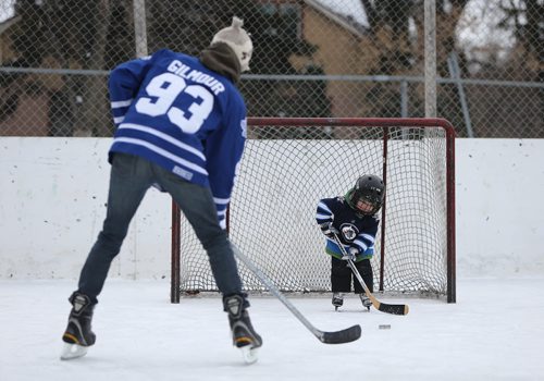 Britt Hainstock takes a shot on his son, Levi, 3, while out for a skate at Robert A. Steen Community Centre in Wolseley on Thurs., Dec. 26, 2013. Photo by Jason Halstead/Winnipeg Free Press