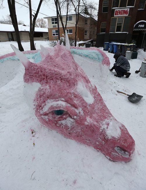 Joe Schwarz works on his 25-foot-long sleeping dragon sculpture made of coloured snow and ice on Wolseley Avenue on Thurs., Dec. 26, 2013. Photo by Jason Halstead/Winnipeg Free Press