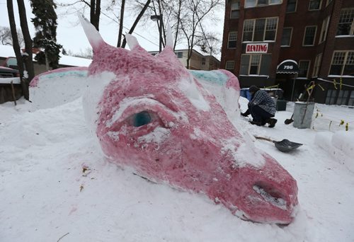 Joe Schwarz works on his 25-foot-long sleeping dragon sculpture made of coloured snow and ice on Wolseley Avenue on Thurs., Dec. 26, 2013. Photo by Jason Halstead/Winnipeg Free Press