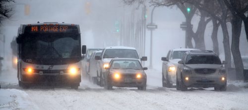 Slow moving traffic during near white out conditions on Portage Avenue in Winnipeg, Saturday, December 28, 2013. (TREVOR HAGAN/WINNIPEG FREE PRESS)