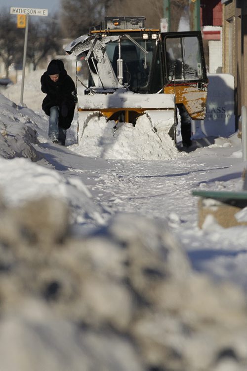 December 29, 2013 - 131229  -  A pedestrian makes her way around a stalled snow blower on Main Street Sunday, December 29, 2013. John Woods / Winnipeg Free Press