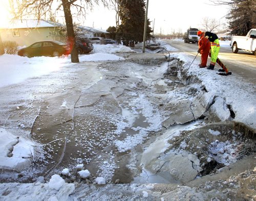 City crews work along the ditch on Laxdal Rd. near Ridgewood Ave. after a major water main break Sunday that has left some resident's front yards covered with ice.  . For web story Wayne Glowacki / Winnipeg Free Press Dec.30. 2013