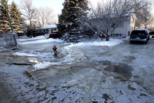 The front of Gordon Ross's home on Laxdal Rd. near Ridgewood Ave. after a major water main break Sunday that has left some resident's front yards covered with ice.  . For web story Wayne Glowacki / Winnipeg Free Press Dec.30. 2013