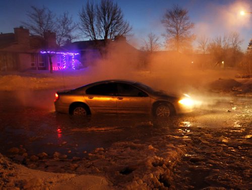 A motorist manages to get out of a flooded section of Jefferson Ave. near Adsum Drive after a major water main break Tuesday morning. Wayne Glowacki / Winnipeg Free Press Dec.31. 2013