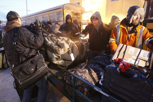 December 31, 2013 - 131231  -  Manitoba Hydro workers load gear onto buses as they arrive back in Winnipeg Tuesday, December 31, 2013 after helping to restore power in Toronto after an ice storm.  John Woods / Winnipeg Free Press
