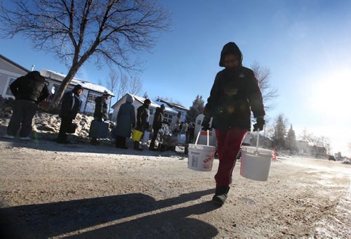 Neeptika Sharma  carries water back to her home off Jefferson Ave after lining up for water at a temporary water supply station set up for people living in the area of a major water main break. Jan 01, 2014 Ruth Bonneville / Winnipeg Free Press