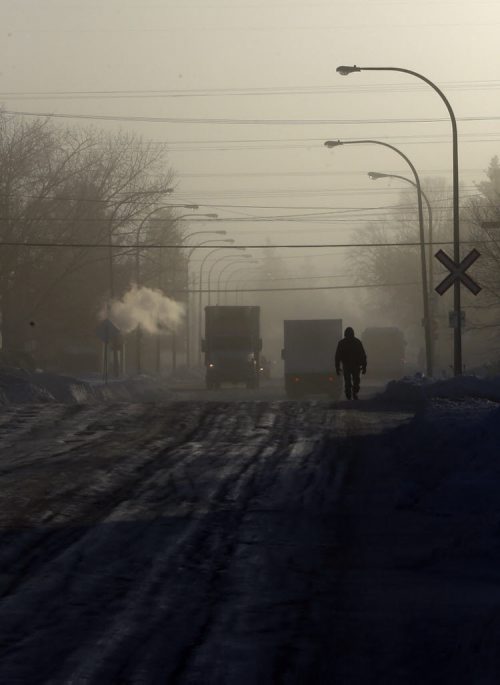 Stdup - NO LONGER PRETTY COLD , a pedestrian walks along  a ice rutted Mountain Ave  in  exhausr fog  and -33 temps  as the bitter un pretty cold continues - JAN. 2 2014 / KEN GIGLIOTTI / WINNIPEG FREE PRESS