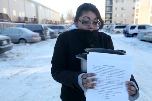 Twenty Two year old Vanessa Singh holds letters slipped under her door from her landlord and the large pots that she filed with boiling water and poured on her tires to try and free her car from the parking lot that filled with water after a water main break on New Years Eve left dozens of  vehicles frozen to knee deep ice. See story. Jan 02, 2014 Ruth Bonneville / Winnipeg Free Press