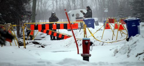 Laxdal Rd residents chat over snow shovels surrounded by barracades Friday afternoon. See Kevin Rollason story. January 3, 2014 - Phil Hossack / Winnipeg Free Press)