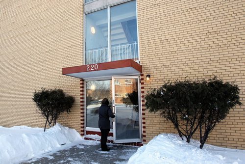 A resident enters the building where Winnipeg police are investigating the first homicide of 2014 after a 69-year-old man was found in an apartment on Fernwood Ave. in St. Vital.  140105 January 5, 2014 Mike Deal / Winnipeg Free Press. Winnipeg's 25th homicide of 2013.