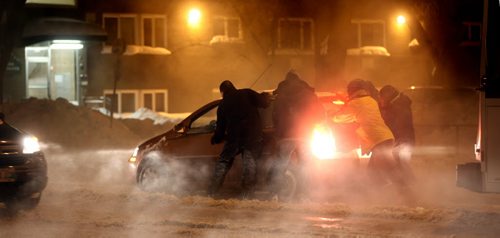 A crowd of volunteers pushes a fog shrouded car Monday evening at Osborne Street and Melborne. A water main break complicated the evening commute flooding Osborne street south with icy sluch sticking her car in place..... January 6, 2014 - (Phil Hossack / Winnipeg Free Press)