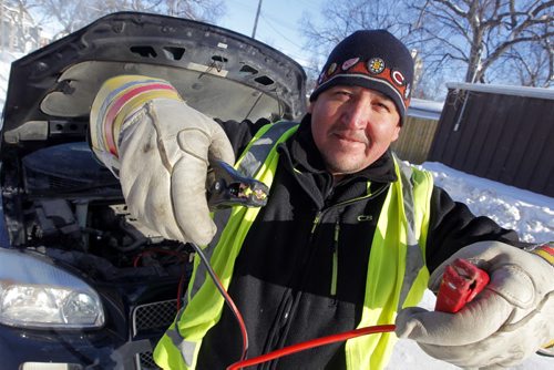 Steve Genaille, 44, is a dad of 5, works for his wife's courier company, caretaker of the three-storey 7 unit apartment building and is going around the city giving battery boosts to people who need help. He charges $20, but only $10 if he can't get it going. BORIS MINKEVICH / WINNIPEG FREE PRESS January 7, 2014