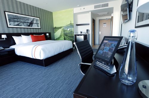 single  room with iPad and water , photo art work in every room  , Runway 36 Executive lounge overlooking  tarmac - The Grand  Winnipeg Airport Hotel Äì martin cash story finance  JAN. 8 2014 / KEN GIGLIOTTI / WINNIPEG FREE PRESS