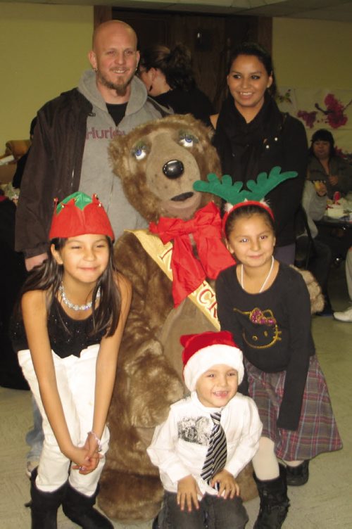 Canstar Community News Dec. 13, 2013 - Curtis Poseluzney and Tonia Peebles and their children Lacey, Laney and Chase gather around Filbert the Bear. (JARED STORY/THE TIMES/CANSTAR COMMUNITY NEWS)