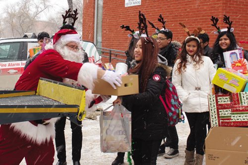 Canstar Community News The jazz choral group from Sisler High School lends a helping hand in loading up a school bus full of food and toys during the Stuff the Bus campaign. (JORDAN THOMPSON)