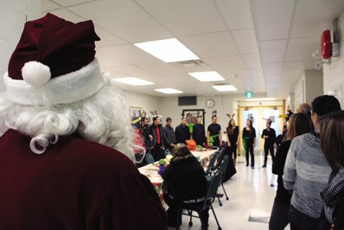 Canstar Community News Employees at the Winnipeg School Division's administration building -- and Santa Claus --are serenaded by the jazz choral group from Sisler High School, before kicking off the Stuff the Bus campaign. (JORDAN THOMPSON)