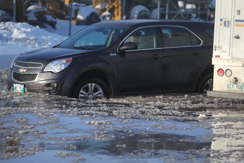 A driver decides to driver through hip deep water  on Holden Street just off Marion Ave. Thursday afternoon after a water main break caused flooding on roads in area and closing down Marion Street just west of Lagimodiere Blvd  Jan 09, 2014 Ruth Bonneville / Winnipeg Free Press